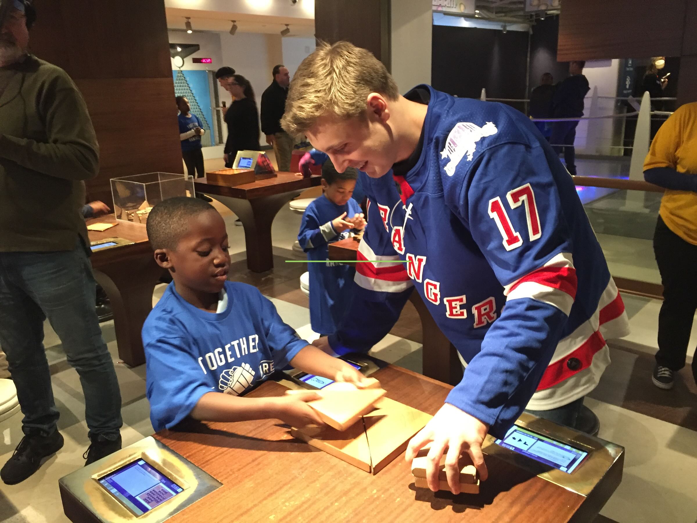 Two smiling people playing with a math puzzle on a table.
