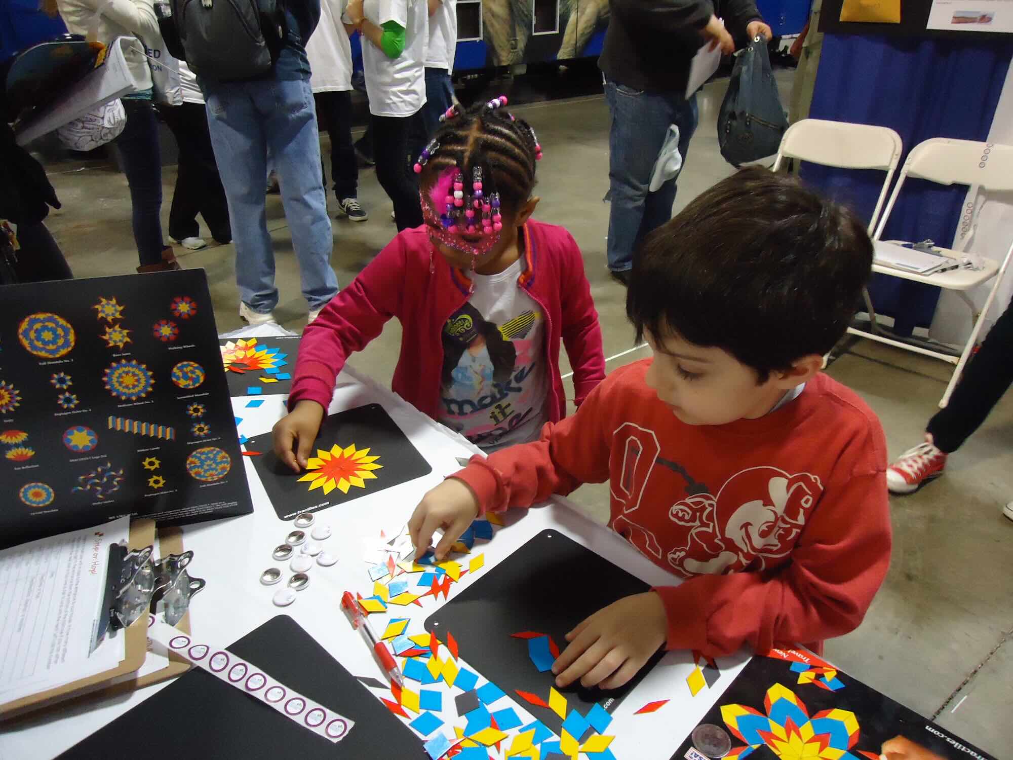 Group of kids looking into a light desk.