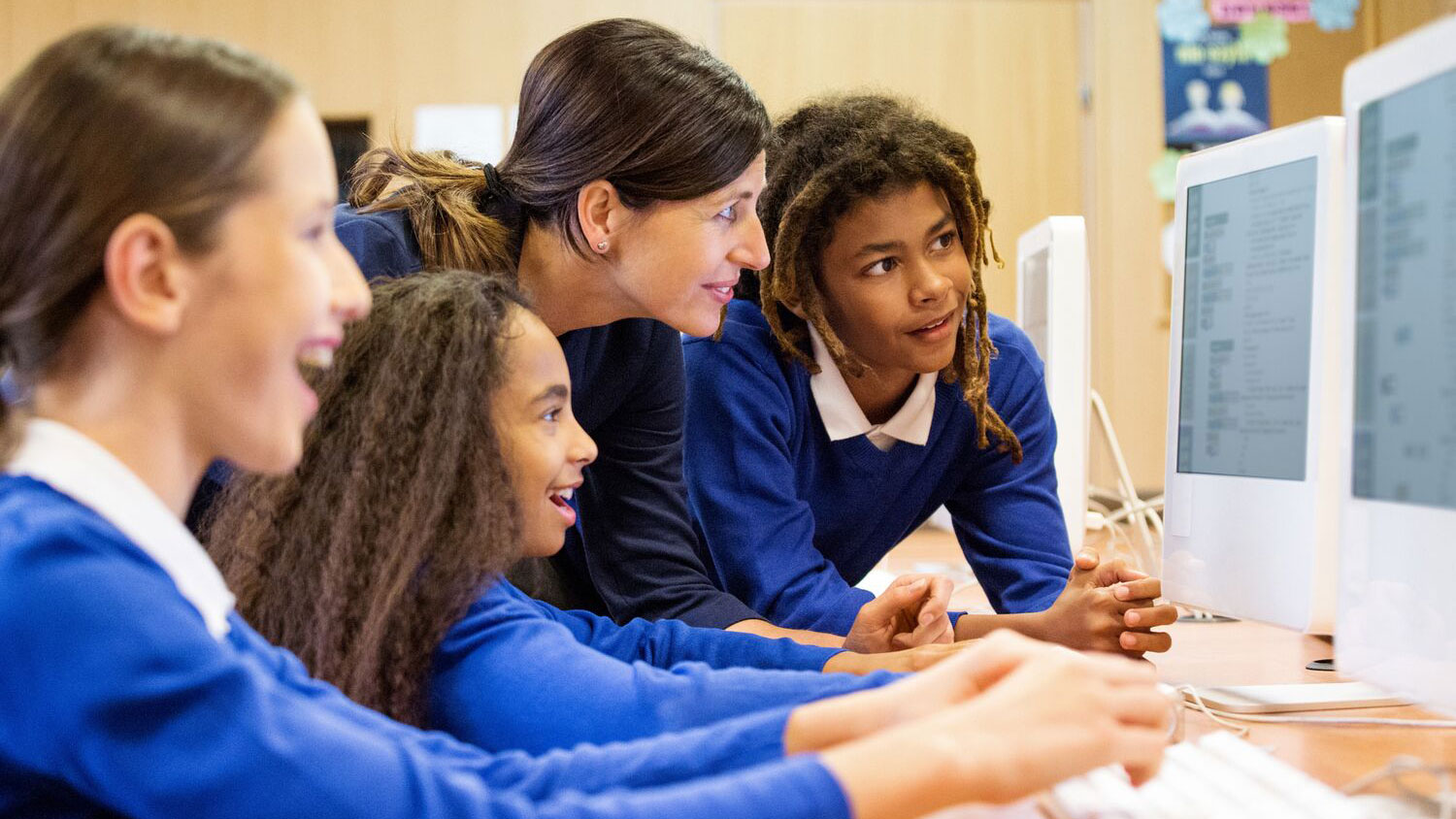 Teacher and group of students looking at a computer screen.